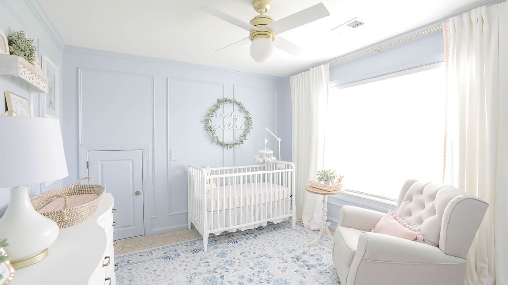 habitación infantil con paredes azul pálido y muebles blancos