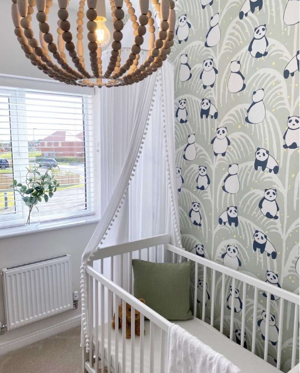 habitación infantil con papel pintado de panda verde y detalles en blanco