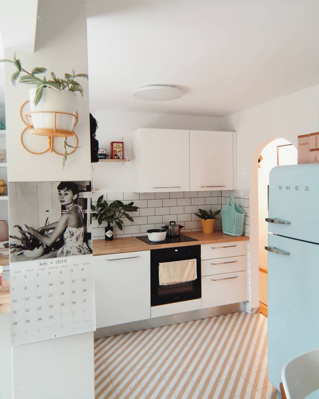 Weiße Küche mit einem blauen Retro-Kühlschrank