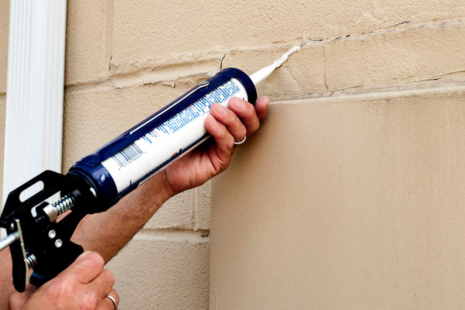 Exterior-grade caulk ceiling gaps in house cracks