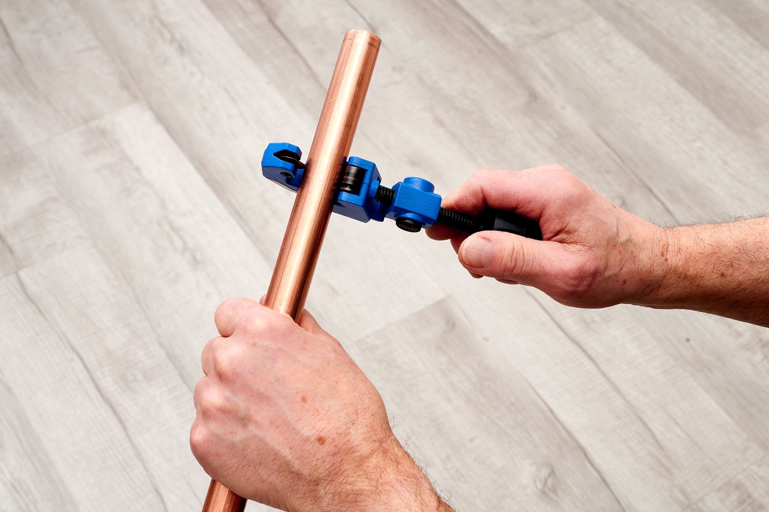 Cortador de tubos azul ao redor do tubo de cobre para corte