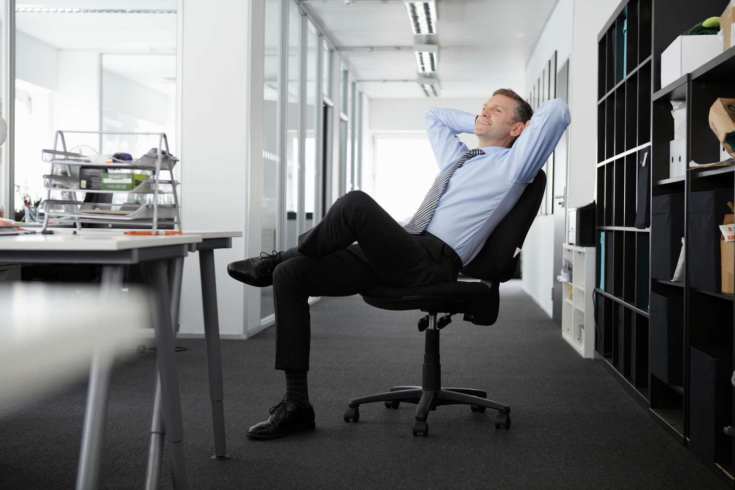 Homme d'affaires mature adossé à une chaise de bureau