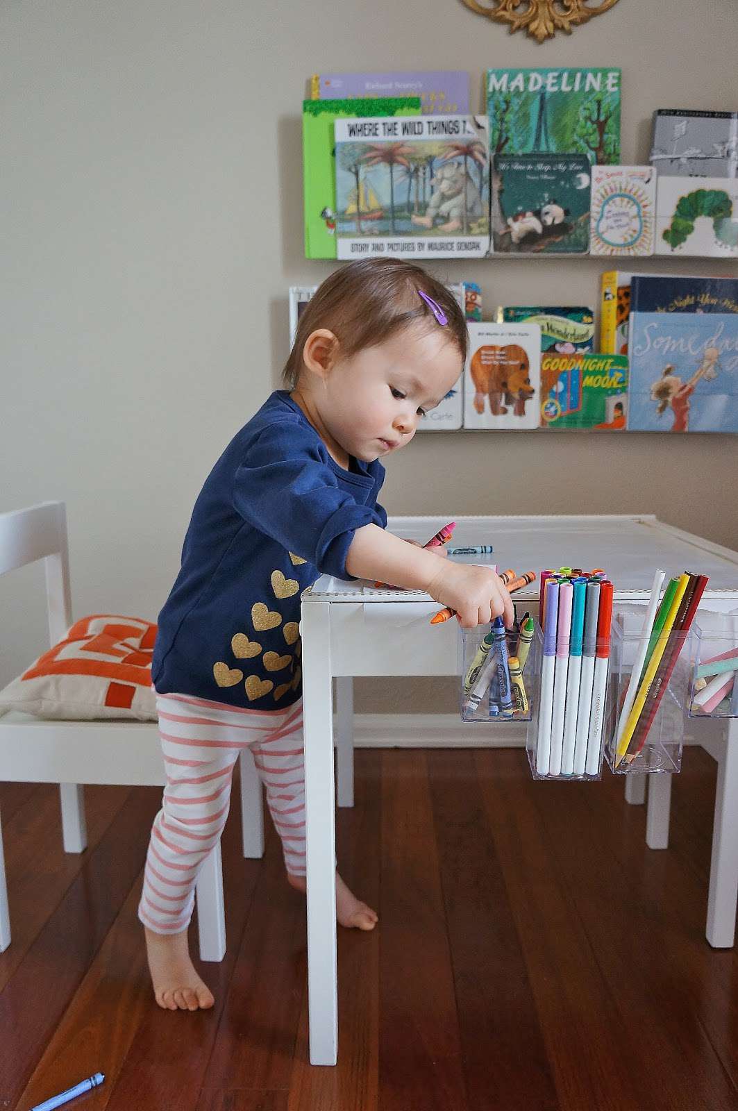 Criança colorindo em uma pequena mesa de desenho feita de um conjunto de mesas Ikea Latt