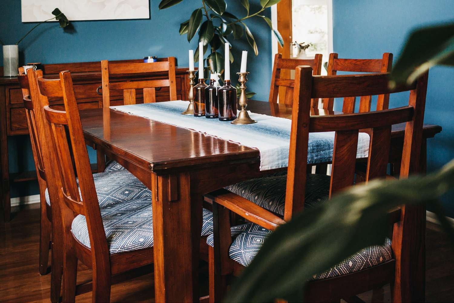 Mesa de comedor de madera de calidad con asientos estampados y velas en el centro