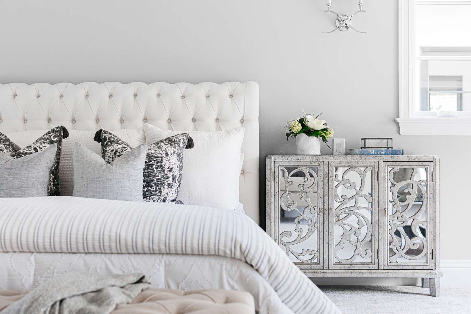 Dormitorio con paredes pintadas de gris claro con gris y blanco y muebles de cama