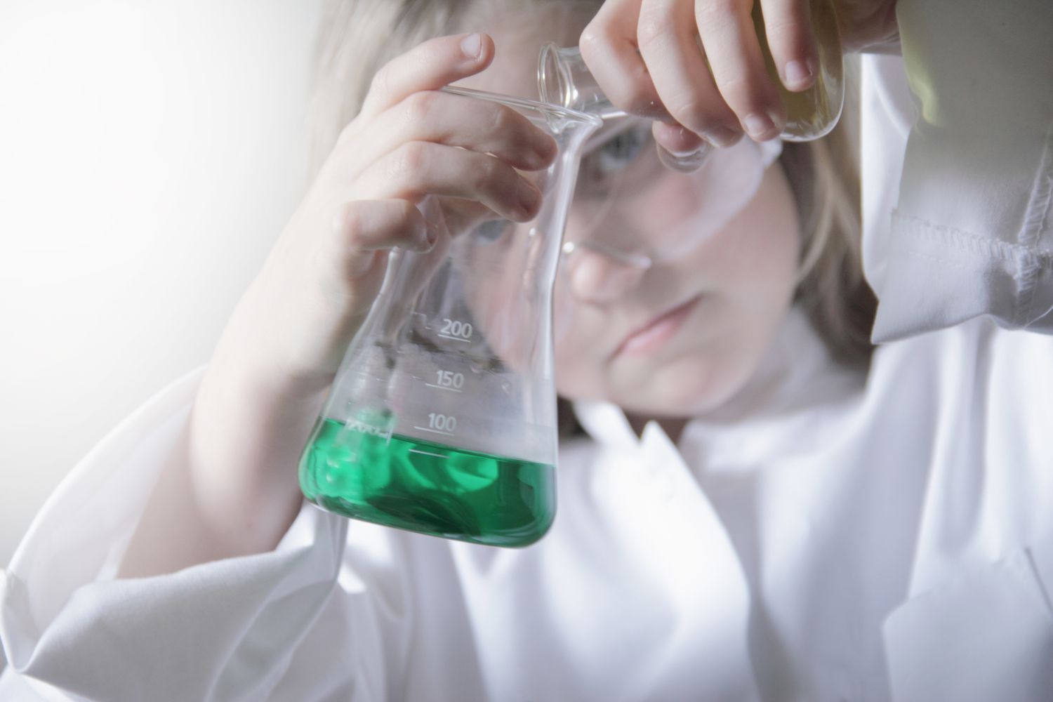 junges Mädchen bei der Durchführung eines wissenschaftlichen Projekts in einem Becher