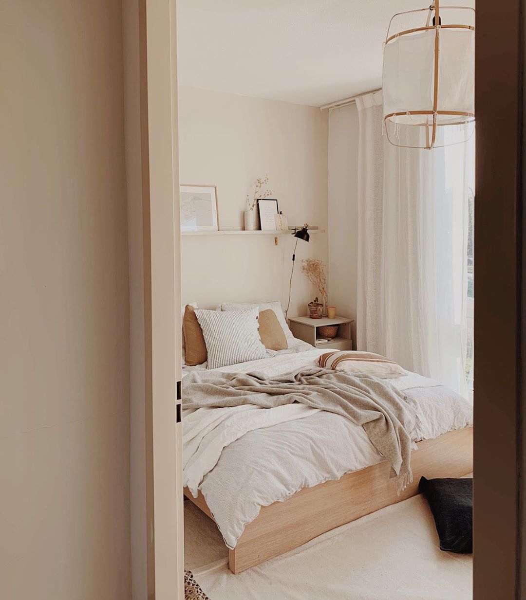 Chambre à coucher avec couleurs claires et meubles en bois