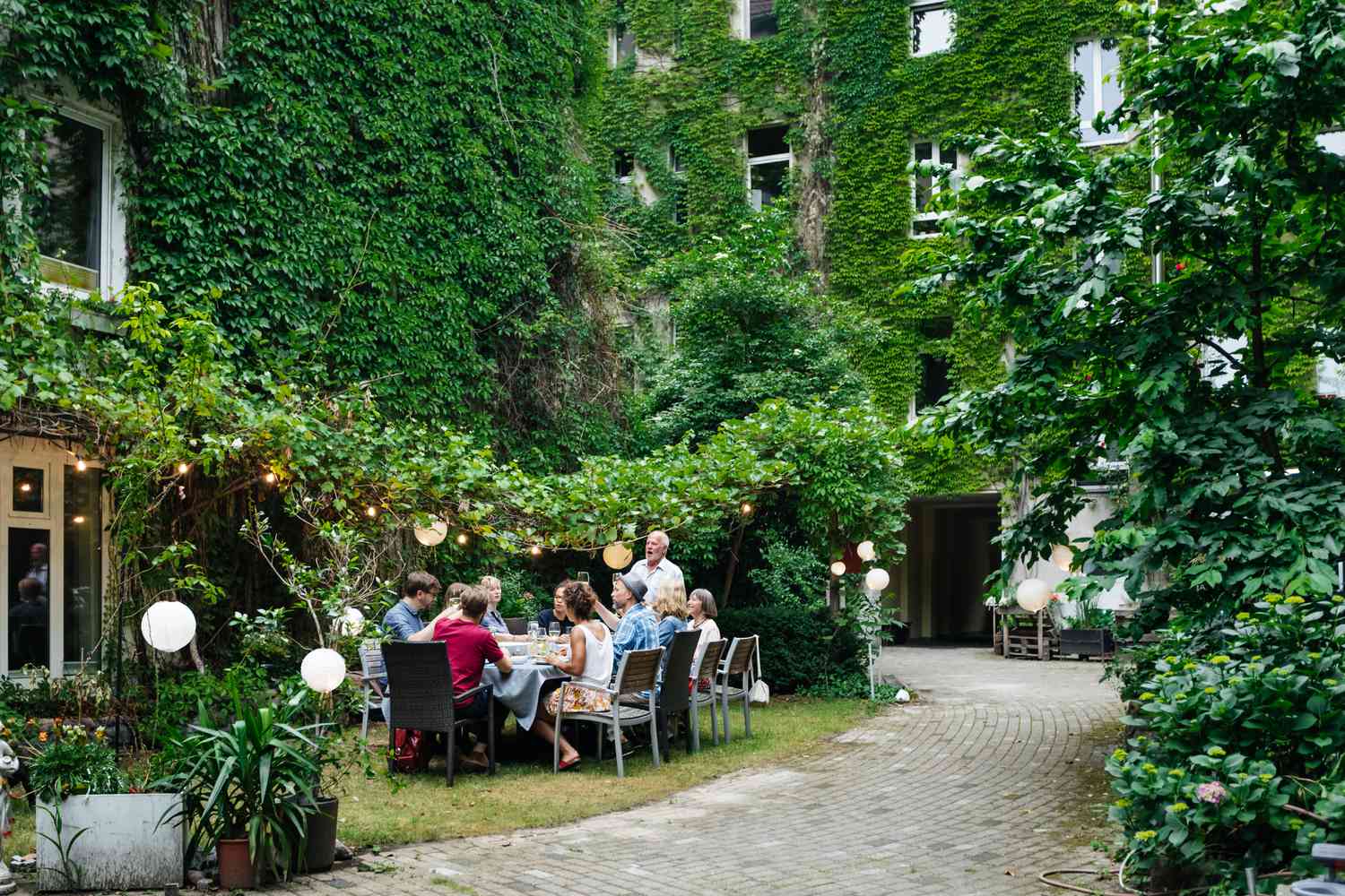 Menschen beim Essen im Freien mit üppigen Pflanzen um sie herum