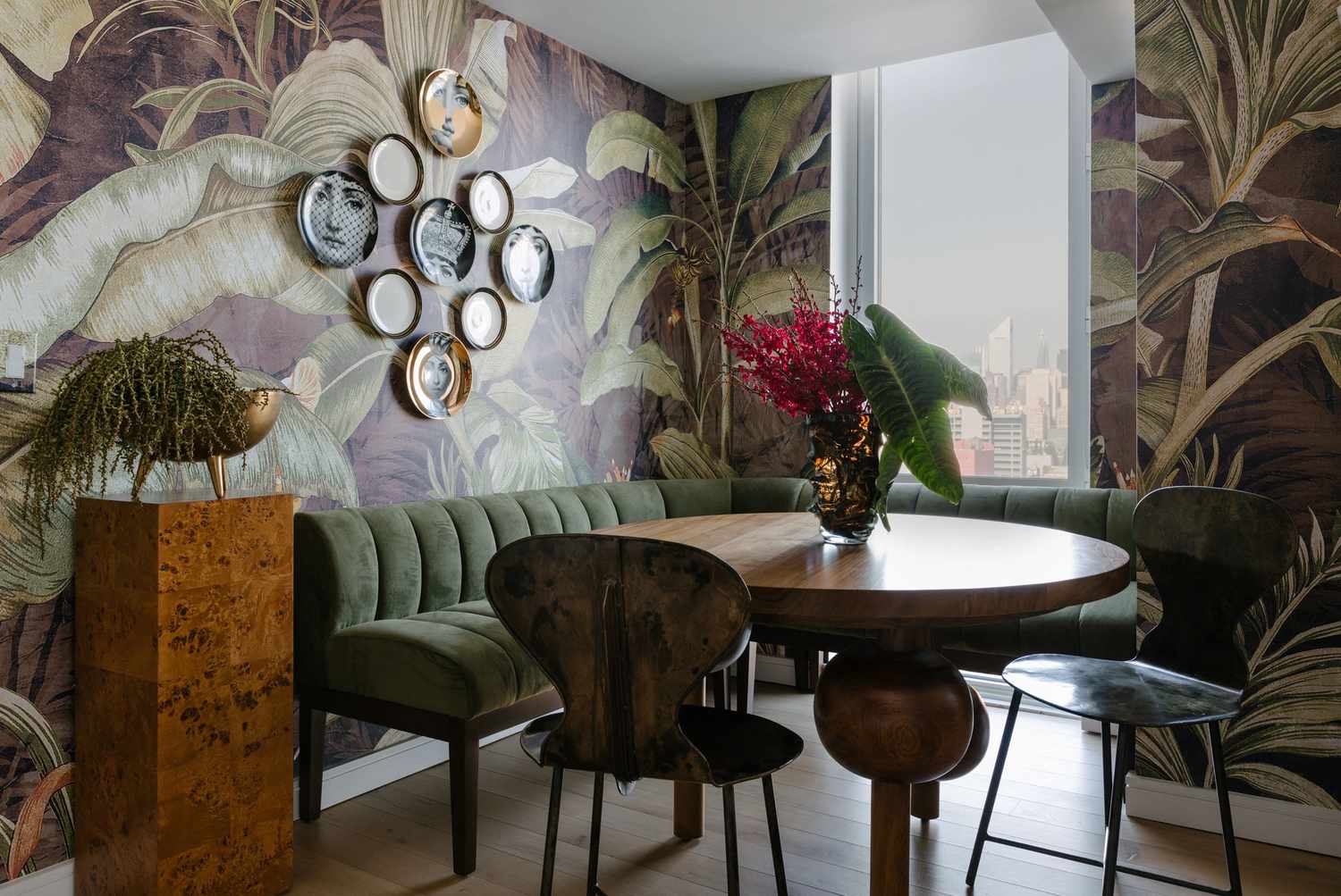 Une salle à manger avec un papier peint botanique audacieux