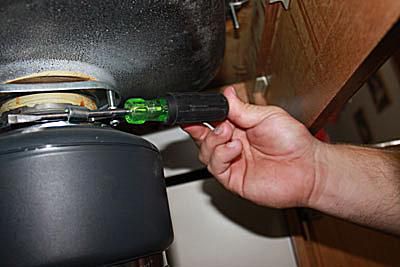 Usando un destornillador para desmontar un triturador de basura