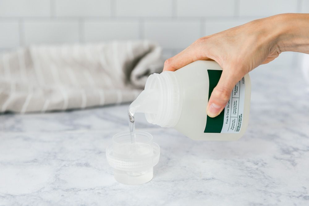pouring detergent into a bottle cap