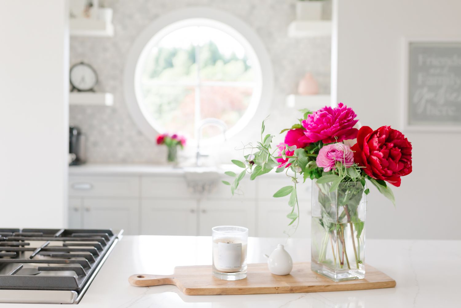 cuisine blanche avec une bougie et des pivoines rouges