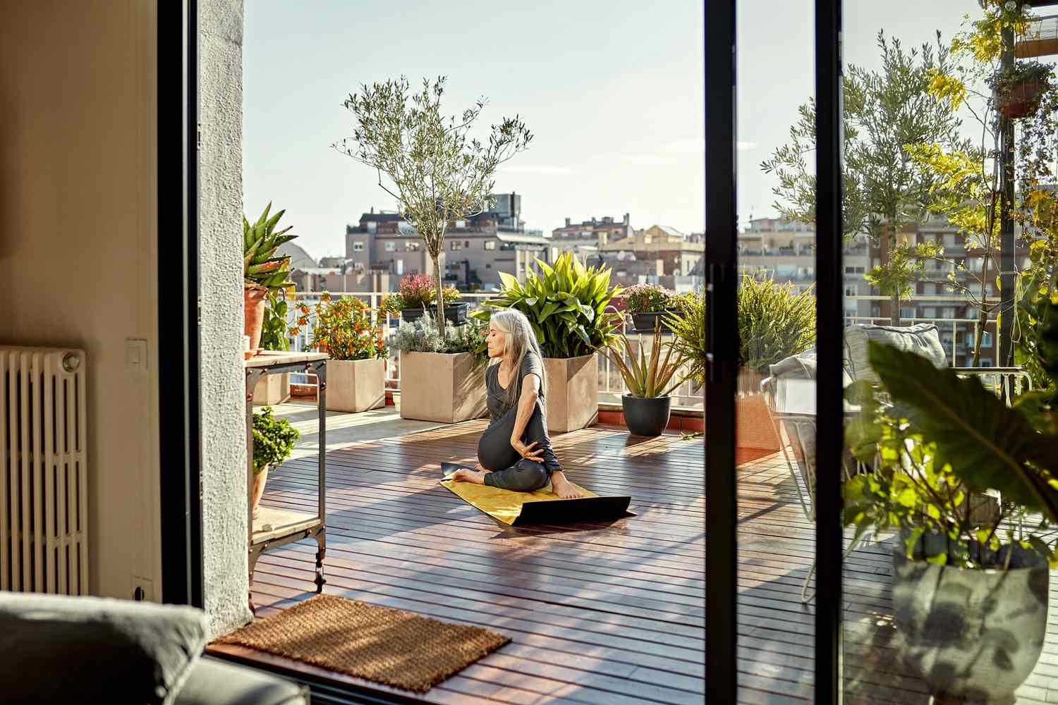 Mujer haciendo yoga en una terraza al aire libre