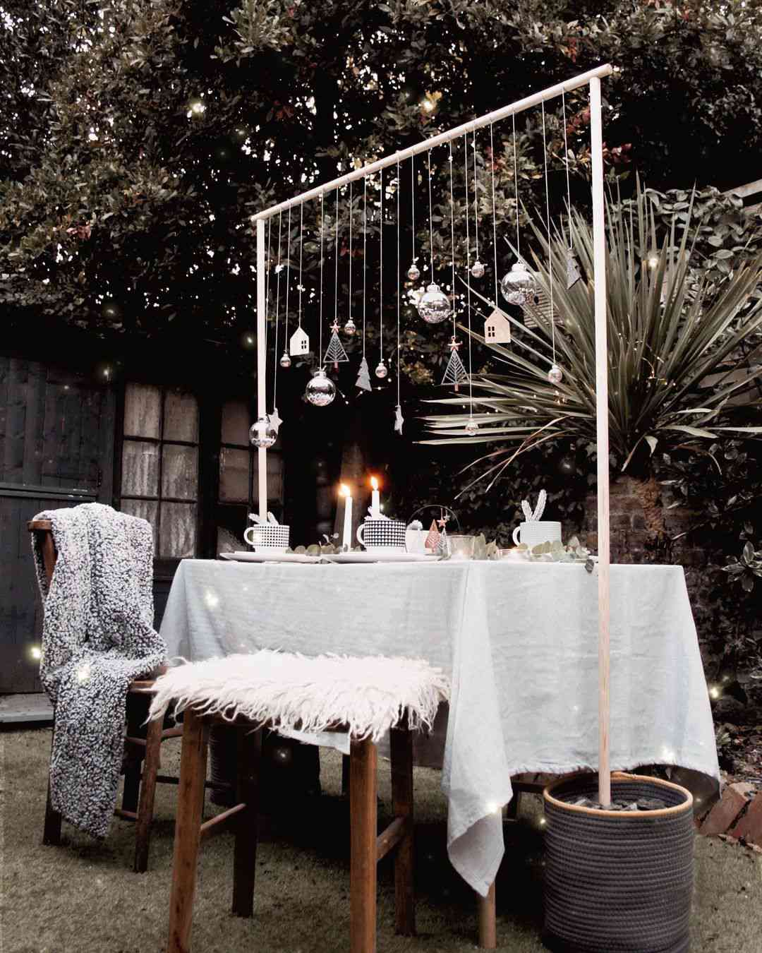 Ein mit Weihnachtsdekoration geschmückter Tisch im Freien, einschließlich eines Aufhängers für die Tischdekoration.