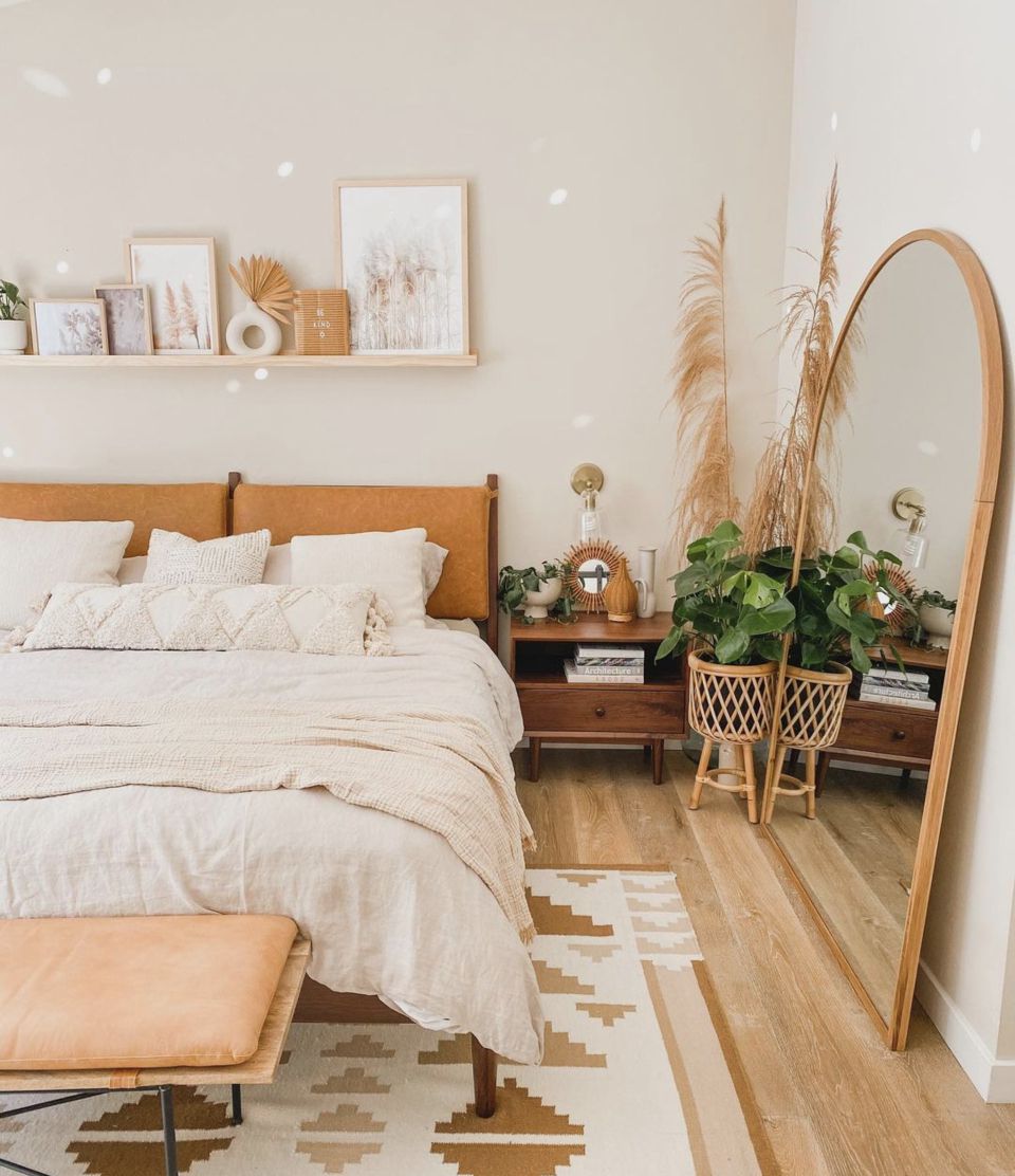 quarto boho com cabeceira acolchoada de couro, espelho de corpo inteiro em arco