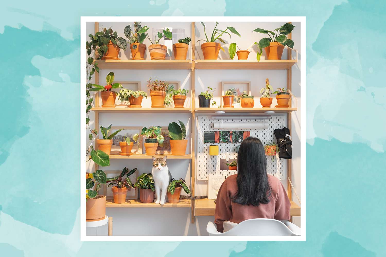 Vionna Wai, Gründerin von @FelineJungle, arbeitet in der Nähe ihrer Pflanzenwand in ihrem Arbeitsbereich zu Hause