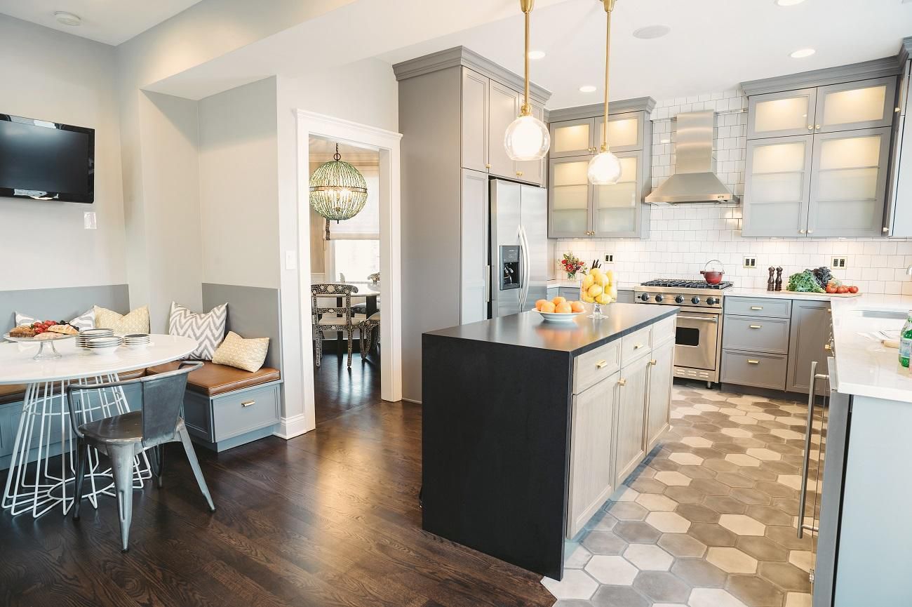 Black waterfall countertop in a hexagon tile and wood floor kitchen