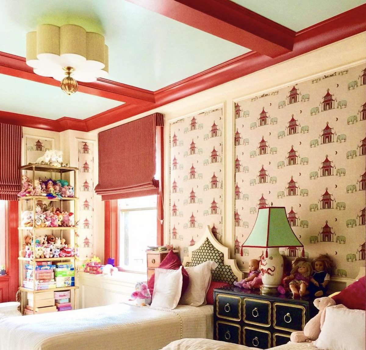 dormitorio infantil con casas rojas en el papel pintado, vigas rojas vistas en el techo