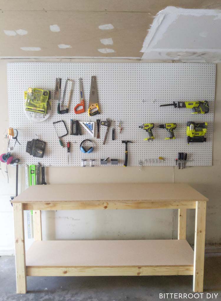 Uma bancada de trabalho e um pegboard com ferramentas