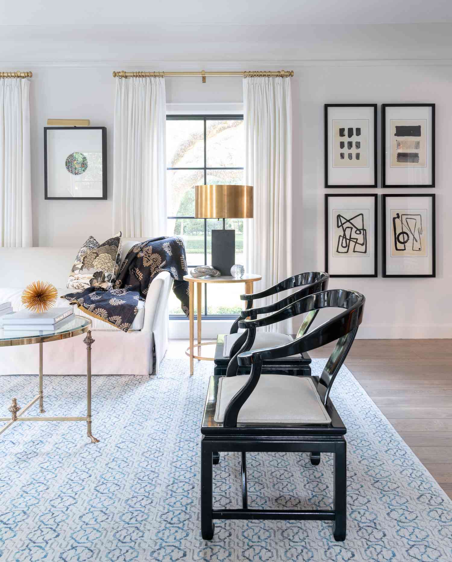 sillas de acento negro adornan este salón con arte minimalista y abstracto