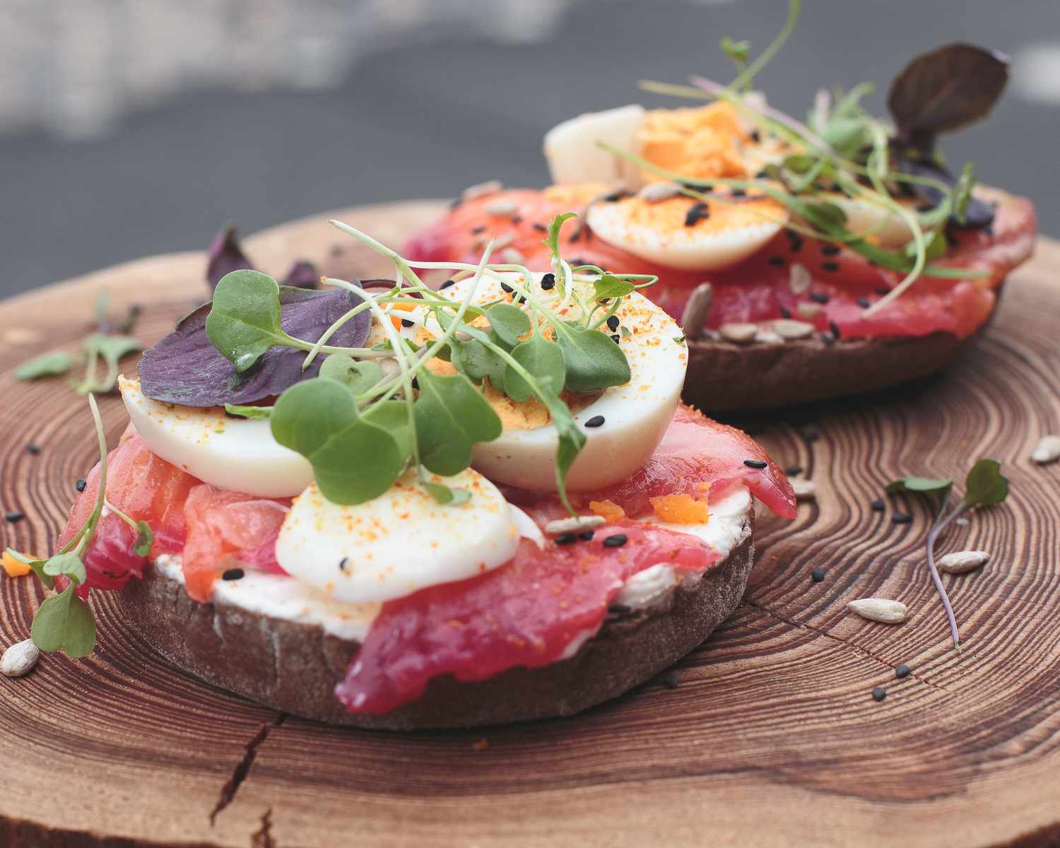 Lachs- und Eiersandwich auf einem Baumstumpf-Teller.