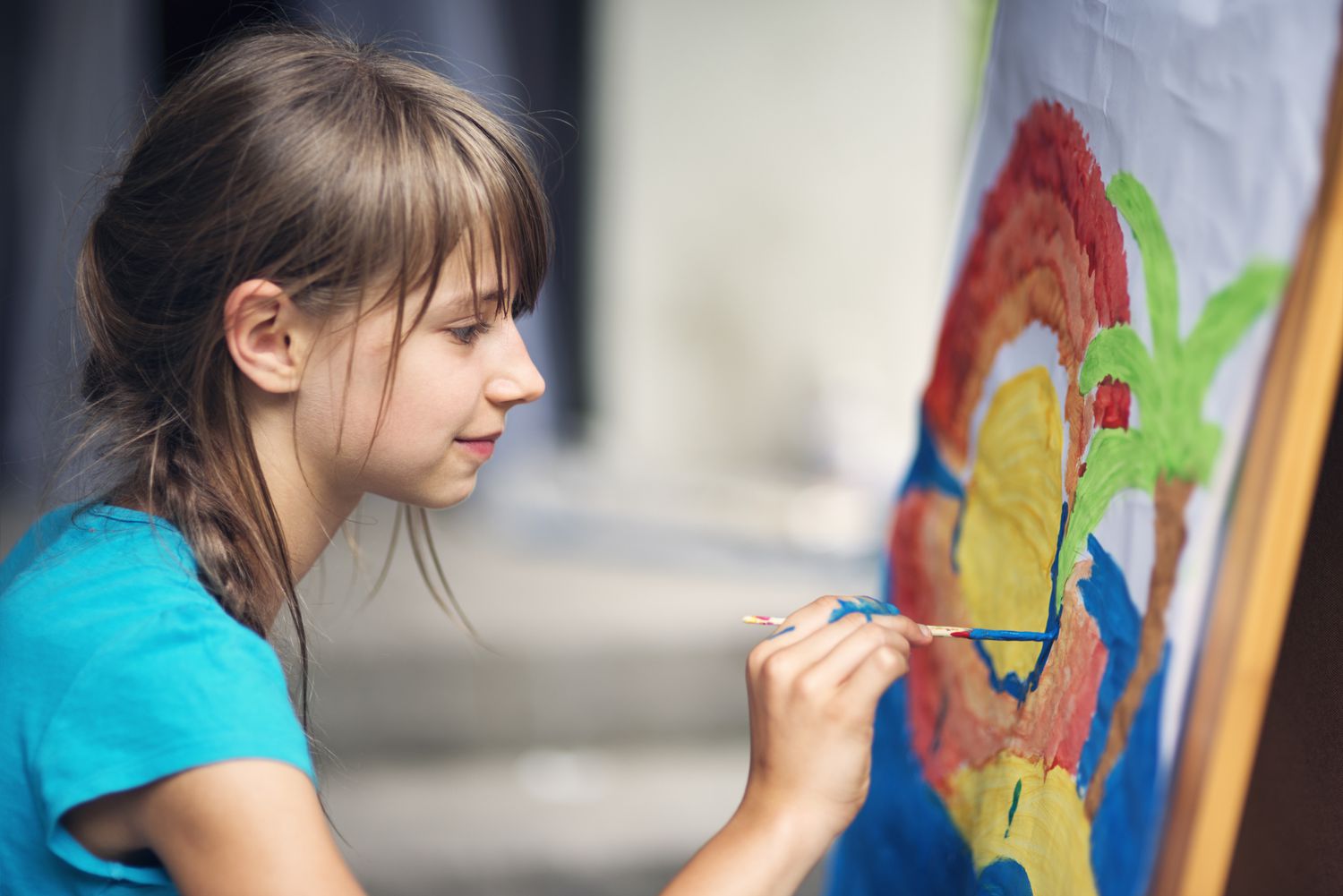 Kleines Mädchen malt auf Staffelei