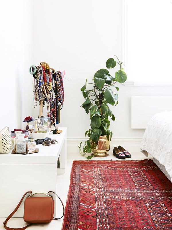 Alfombra kilim roja en un dormitorio blanco