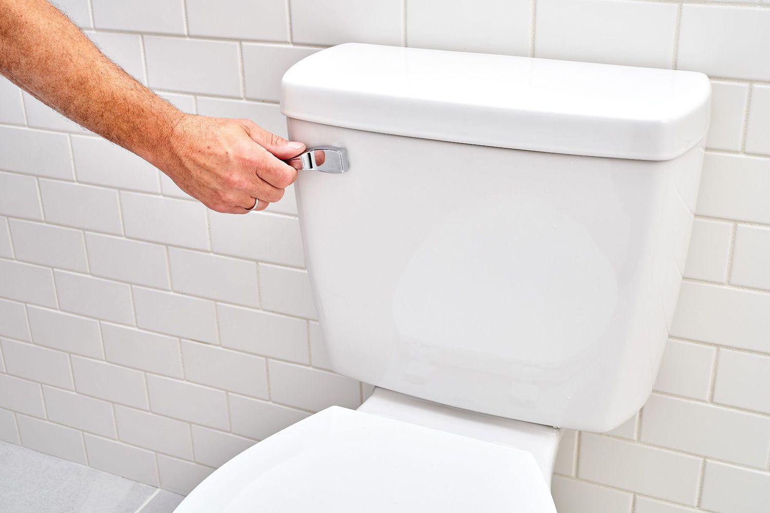 Toilet handle being pressed down to flush toilet