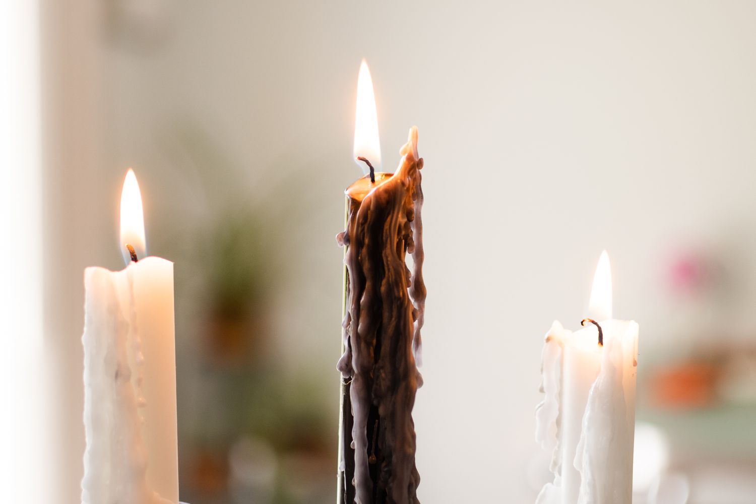 Brauner und weißer Kerzenständer mit kleiner Flamme in Nahaufnahme