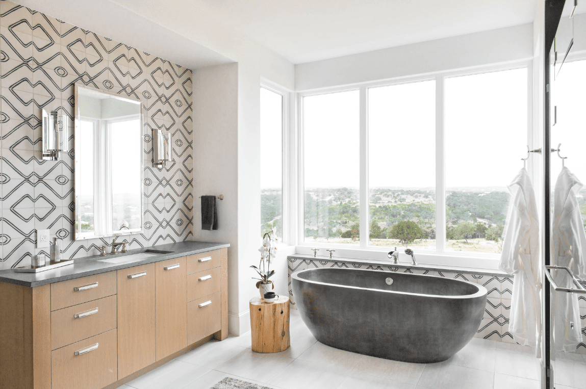 Betonbadewanne mit großem Panoramafenster, Waschtisch und Spiegel.
