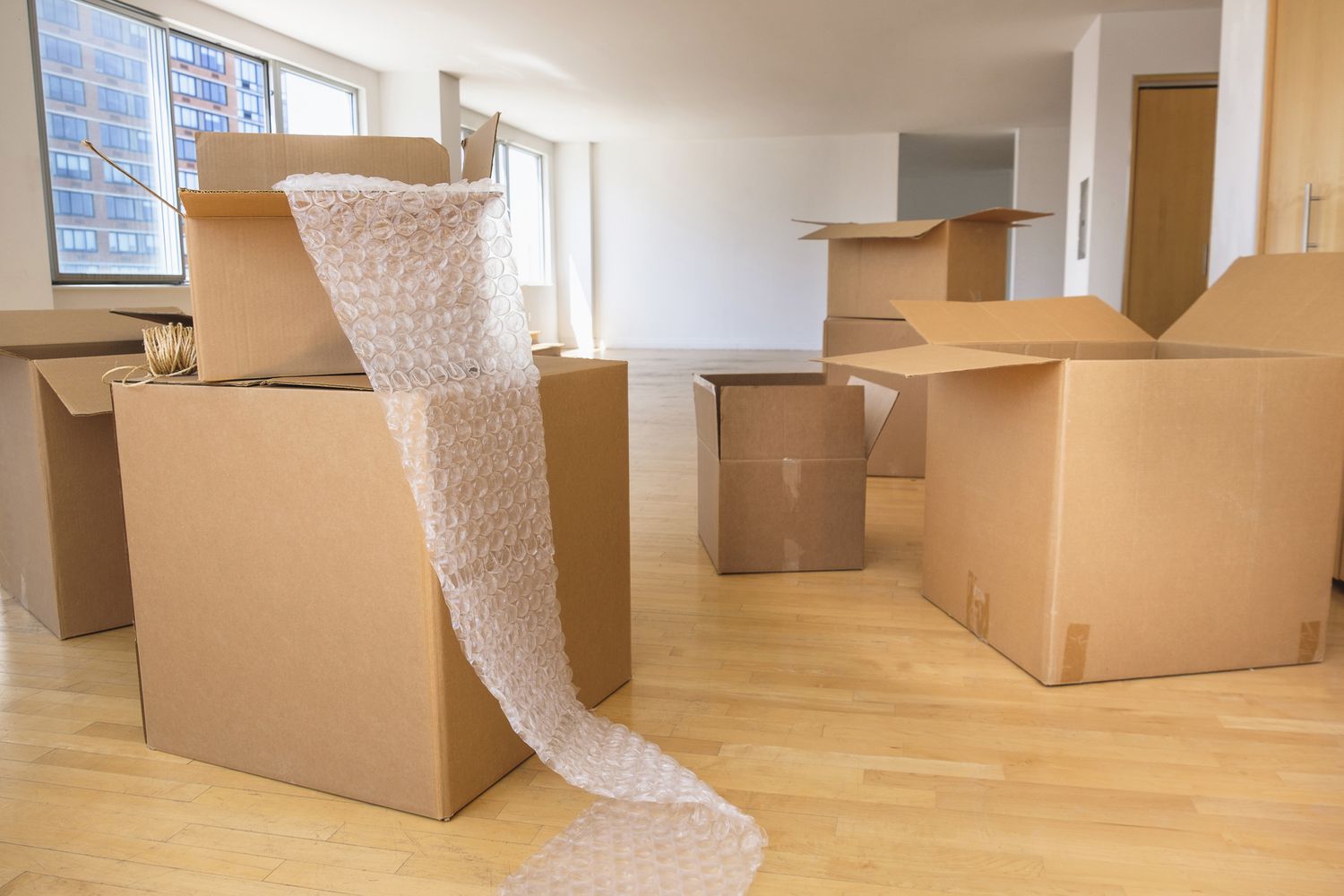 Cardboard boxes and bubble wrap in empty apartment