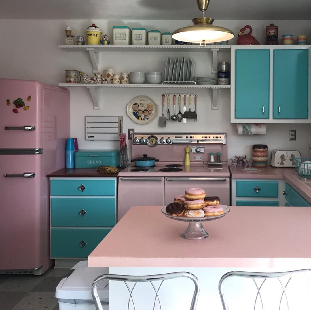 Küche mit rosa und blauen Schränken
