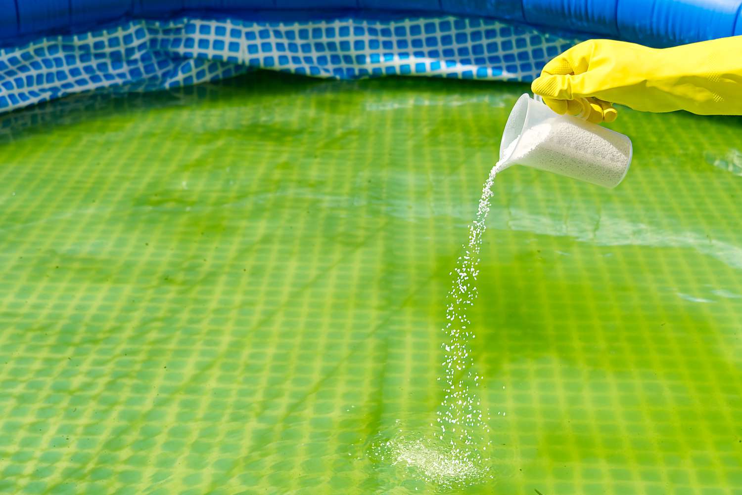 Zugabe von Chlorpulver für den Pool zur Algenentfernung und Wasserdesinfektion. aufblasbares Schwimmbadpflegekonzept.