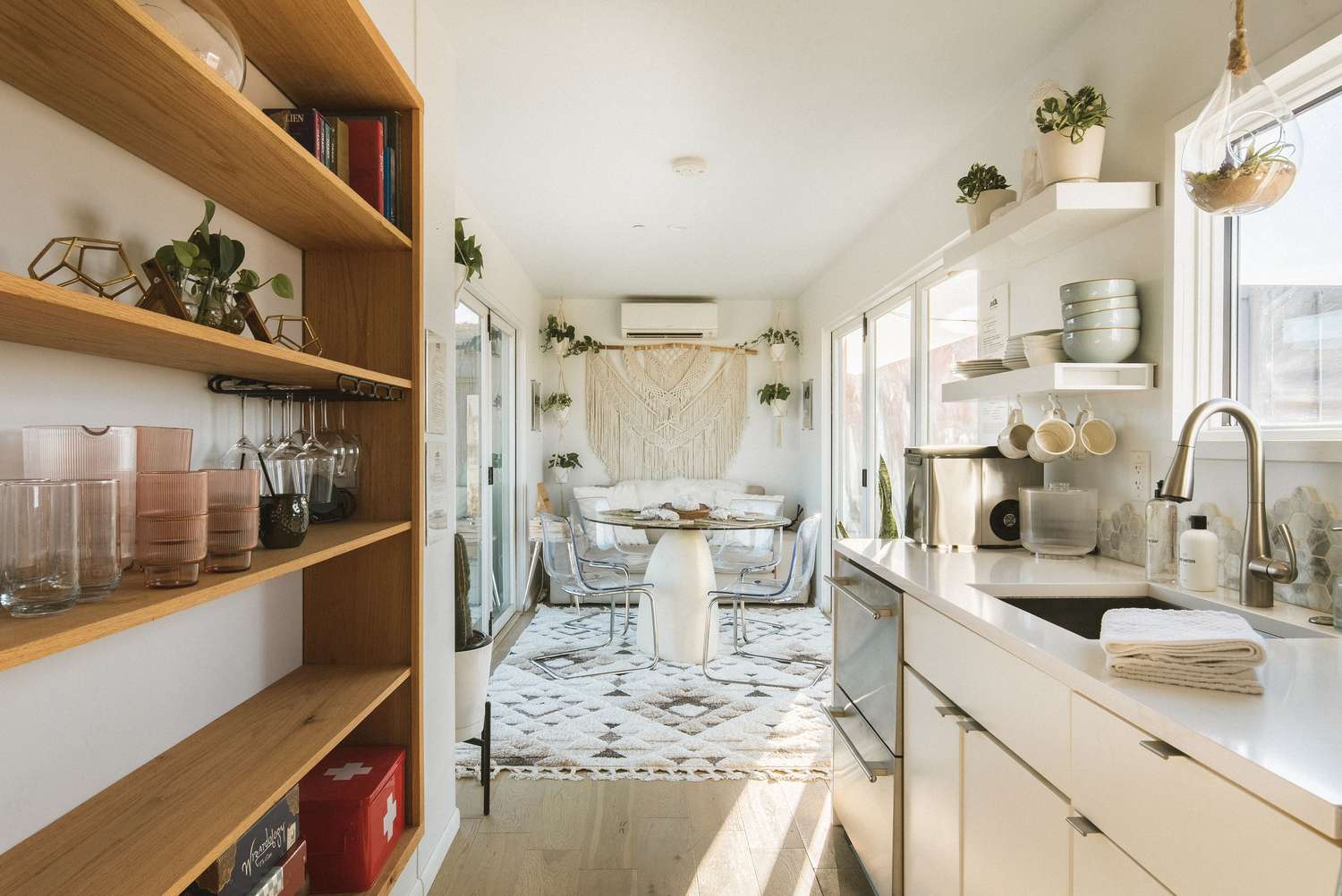 Salón largo y estrecho decorado con muebles claros