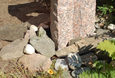 Große Felsen verdecken das Gitter des Steinbrunnens am besten.