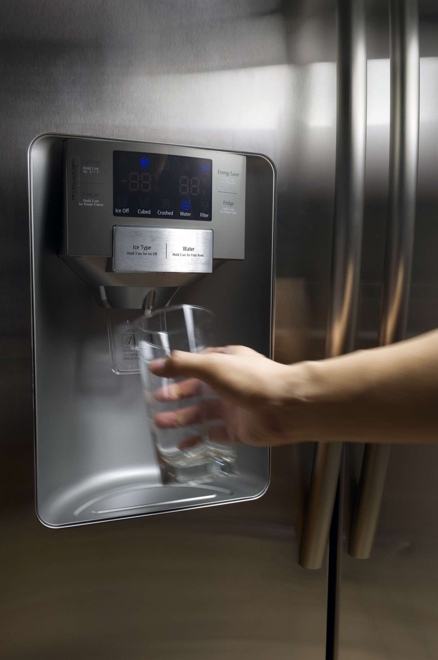 Handausgabe von Wasser aus einem externen Wasserspender an einem Kühlschrank.