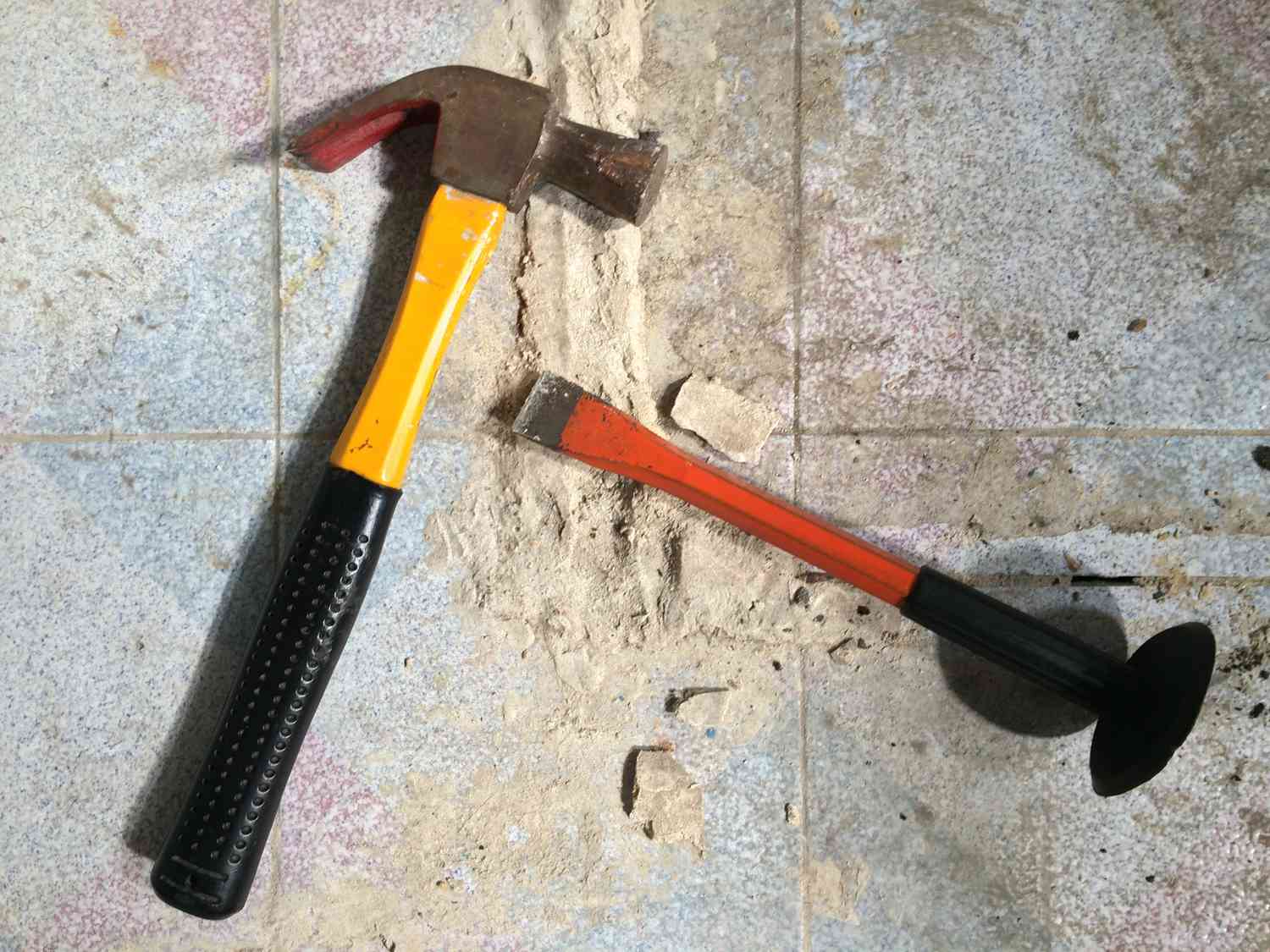 Hammer and chisel on tile floor