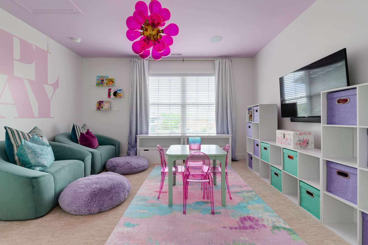 Um quarto de jogos infantil com tema rosa, roxo e turquesa