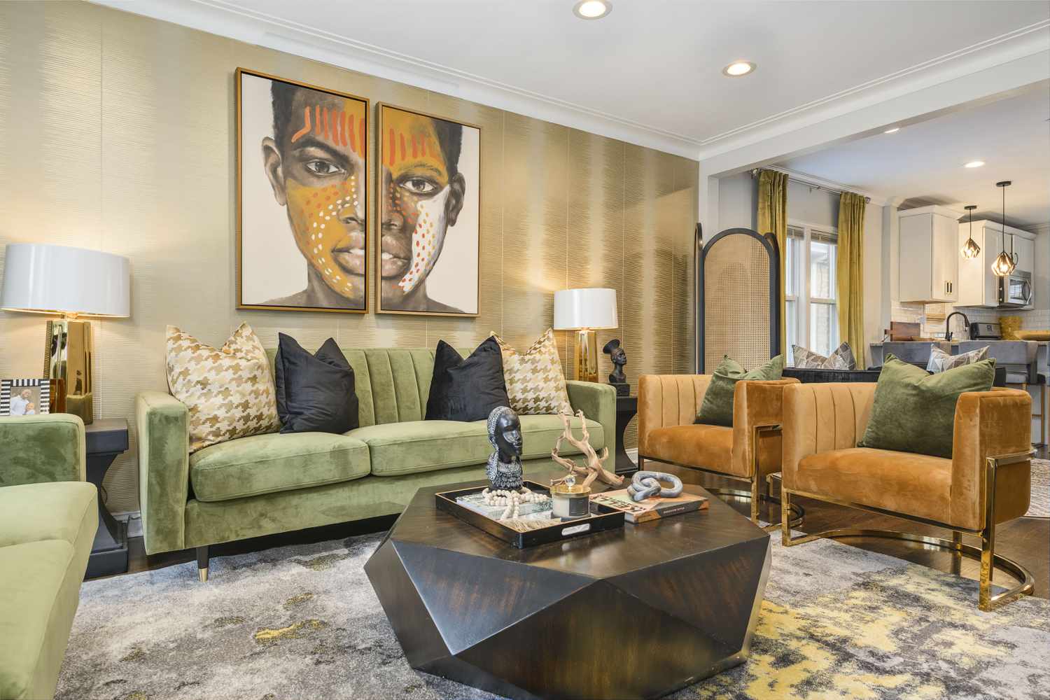 Salón con sofá de terciopelo verde, sillas de terciopelo marrón y cuadros de inspiración africana en la pared