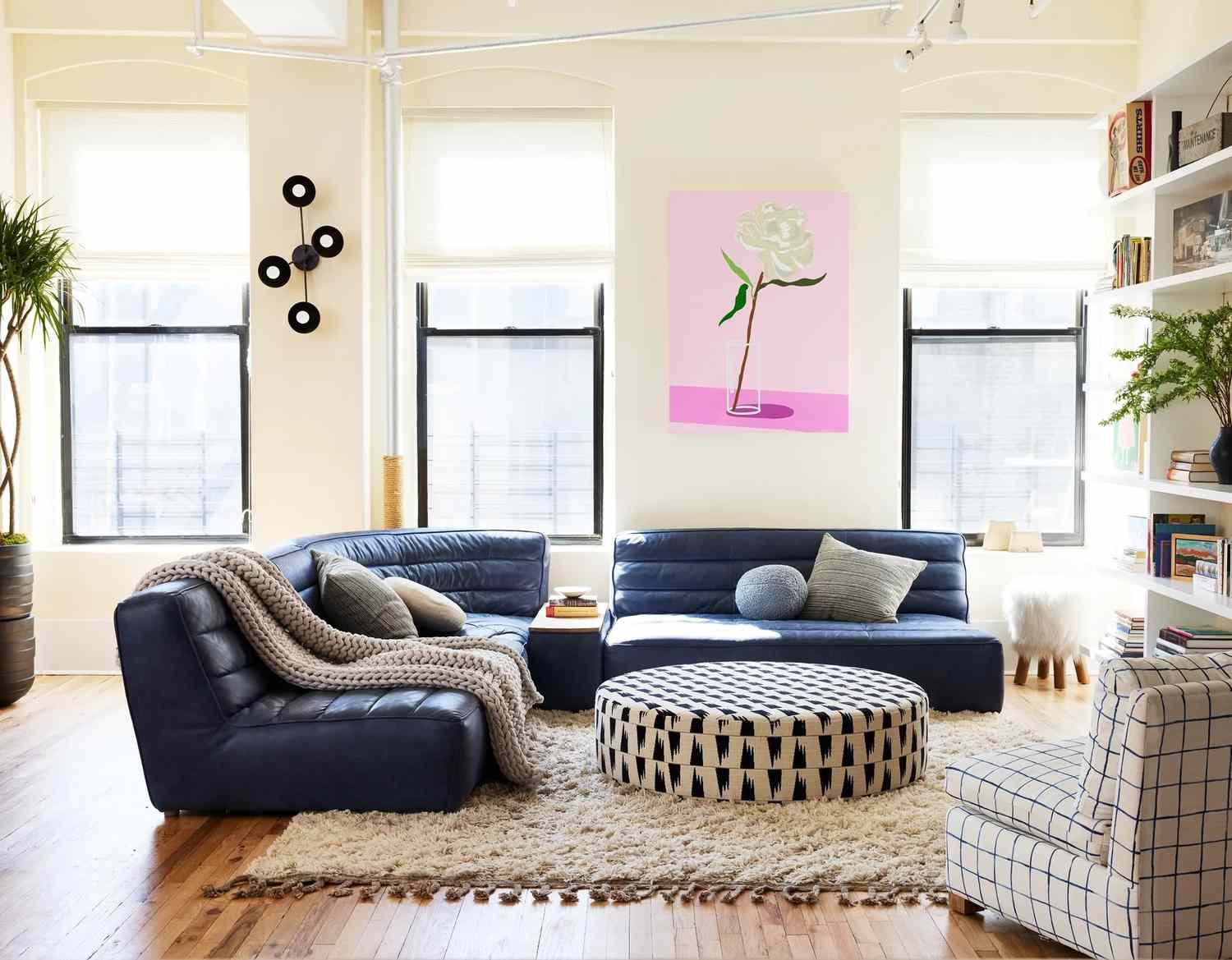 Sala de estar ampla com um sofá azul e tapete branco.