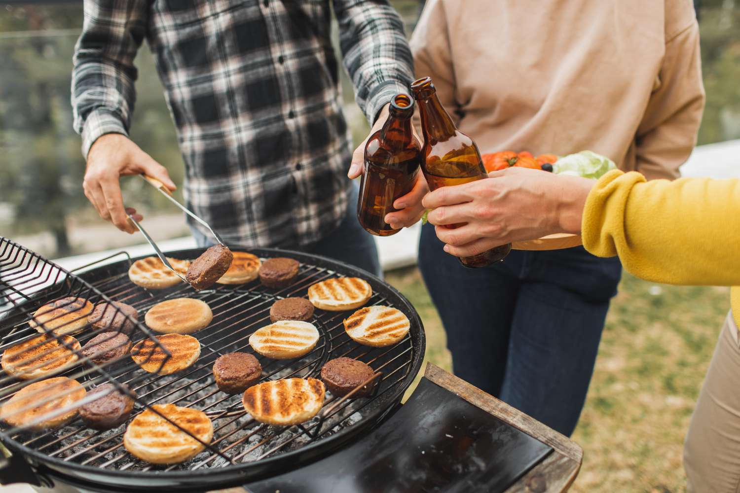 hambúrguer na grelha com amigos aplaudindo copos