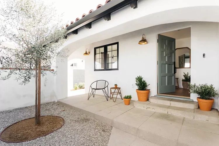 Eine spanisch inspirierte Hausfassade mit einer olivgrünen Tür
