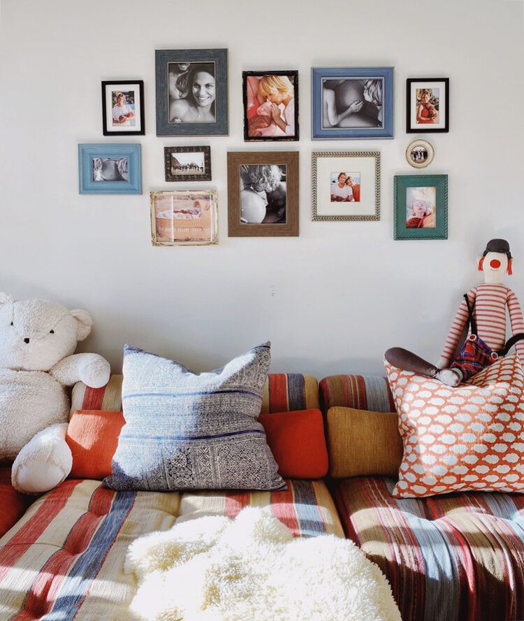 Coloridas fotos familiares encima de un sofá estampado