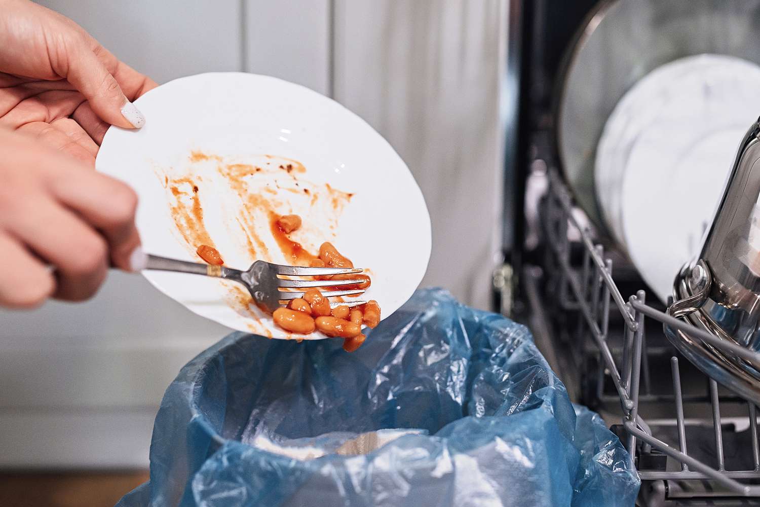 Abkratzen von Lebensmitteln vor dem Einräumen des Geschirrs in die Spülmaschine