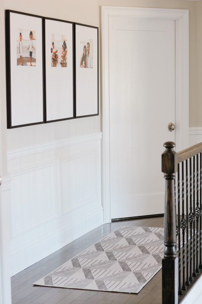 Hallway With Square Family Photos In Large Frames