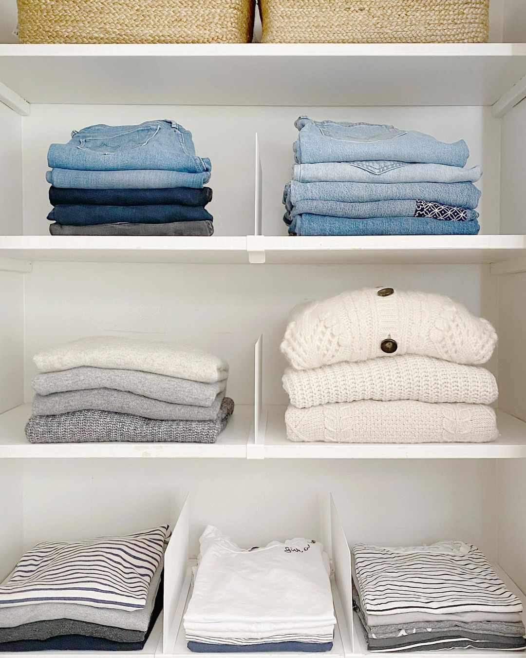 Uma prateleira de armário com roupas dobradas