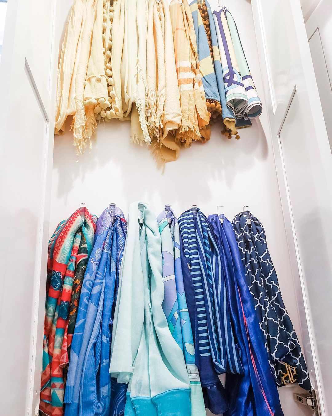 Une armoire avec des crochets acryliques pour suspendre des foulards