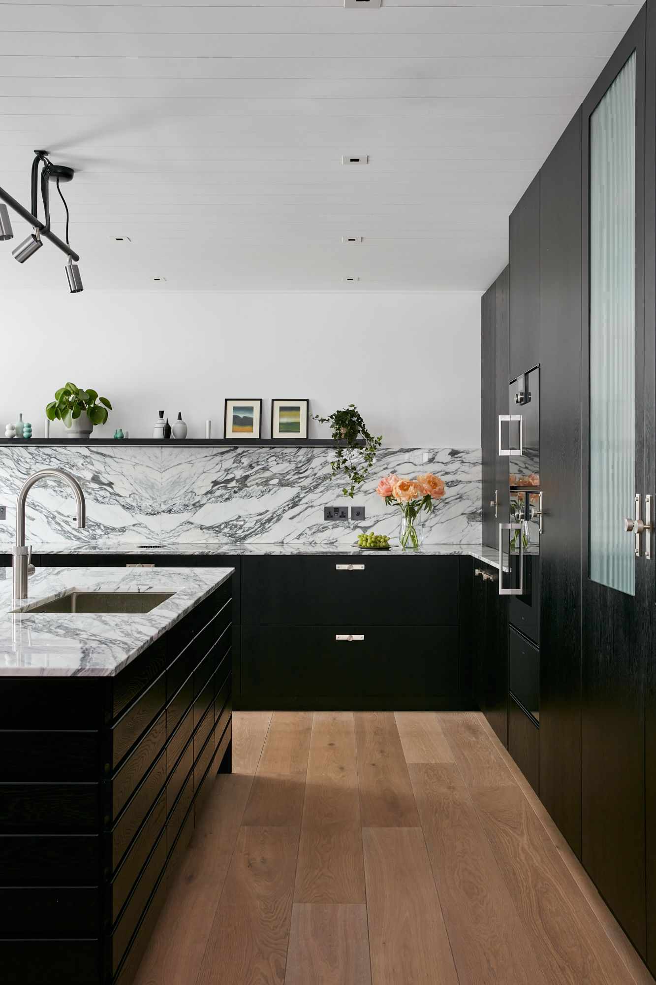 armários de cozinha pretos escuros com detalhes em mármore