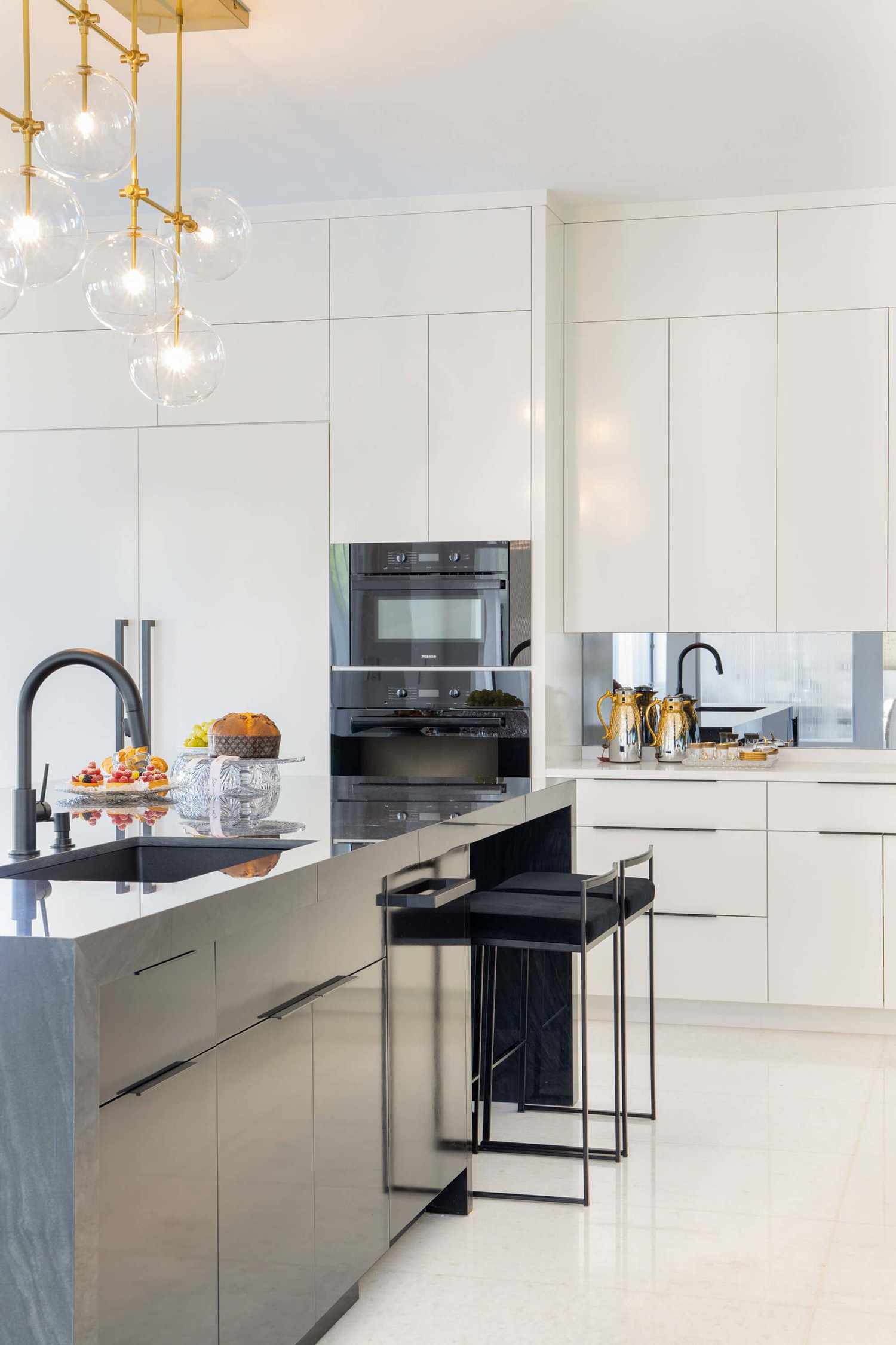 mirrored backsplash with white cabinets