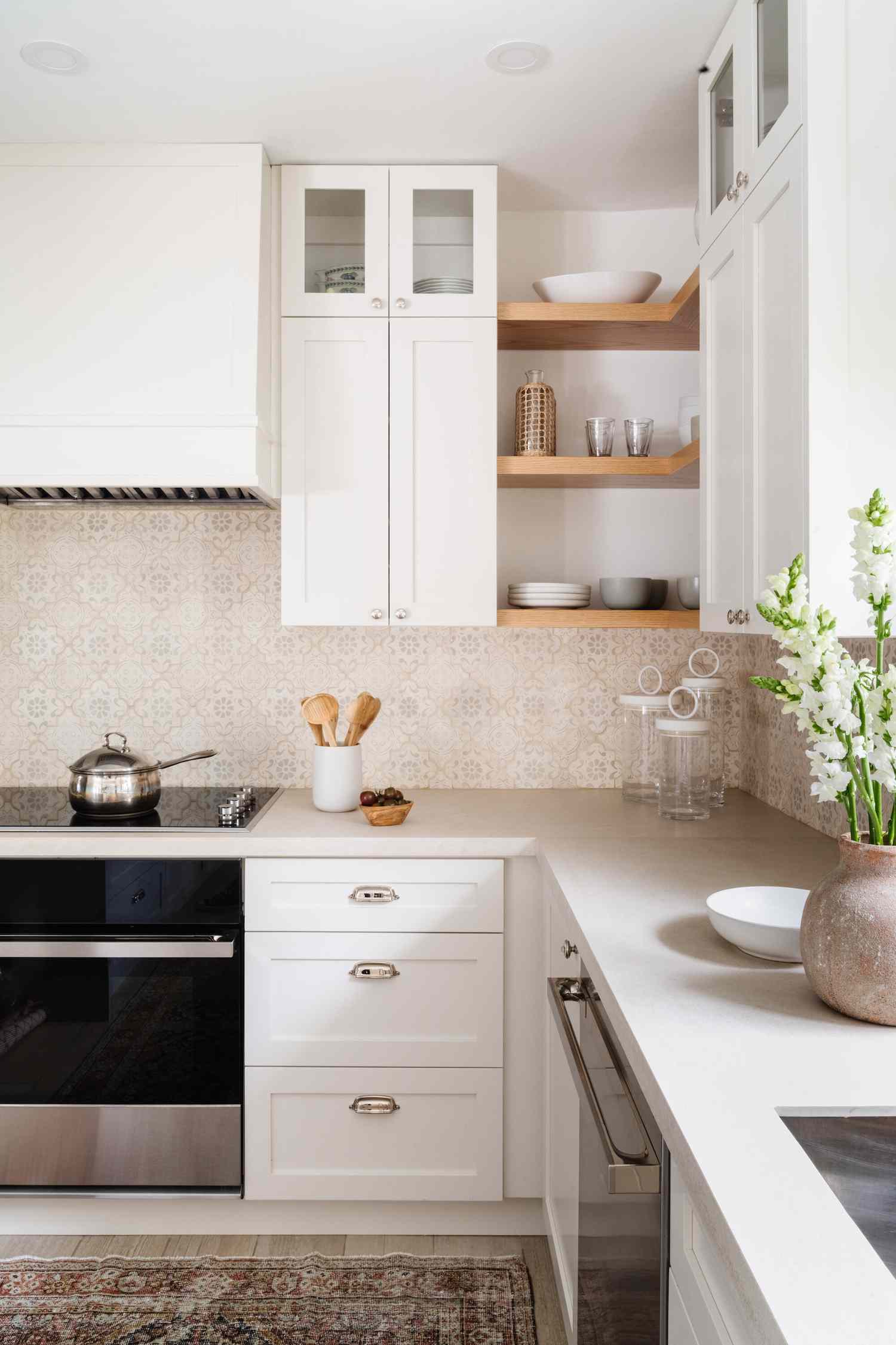 beige patterned tile backsplash with white cabinets
